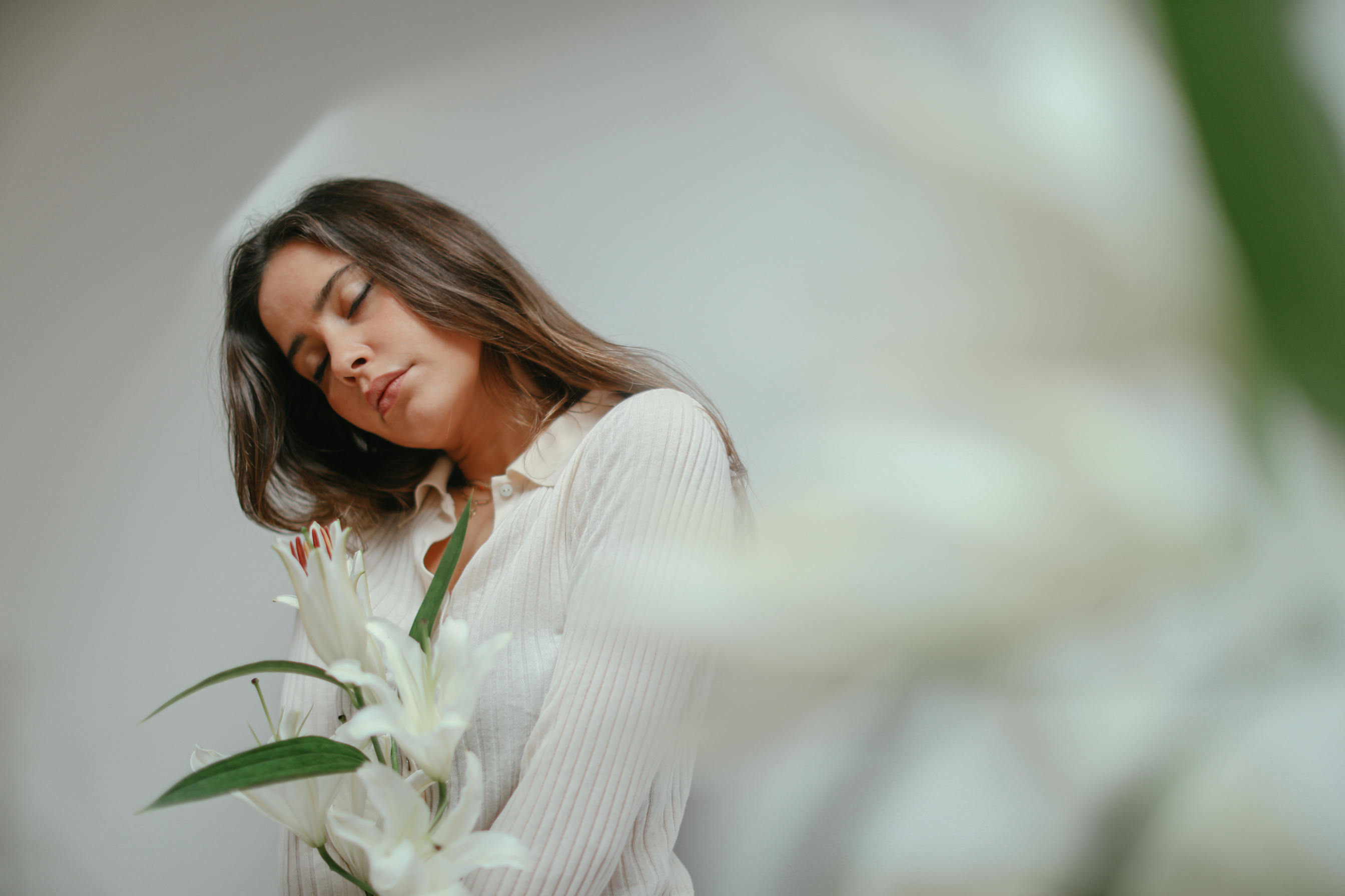 Beautiful Woman with Eyes Closed Holding White Flowers